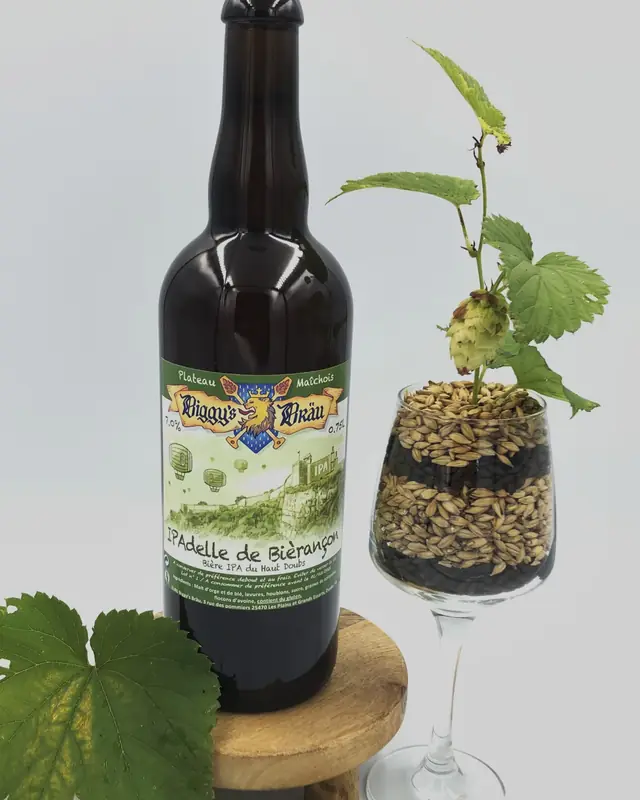 Bouteille d'IPAdelle de Bièrançon à côté d'un verre de malt et de houblon