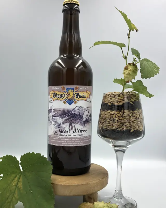 Bouteille de Mont d'Orge à côté d'un verre de malt et de houblon